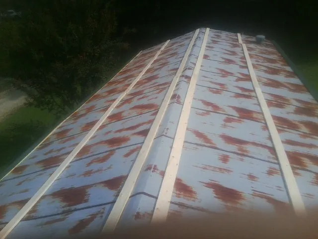 Rusted metal roof panels with new wood purlins before replacement — Storm Damage Roof Repair in Grubville by Roofing Brothers